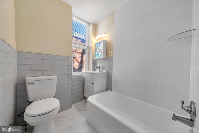 bathroom featuring a washtub, toilet, a wealth of natural light, and tile walls