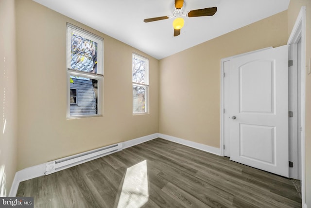 spare room with baseboard heating, ceiling fan, and dark hardwood / wood-style floors