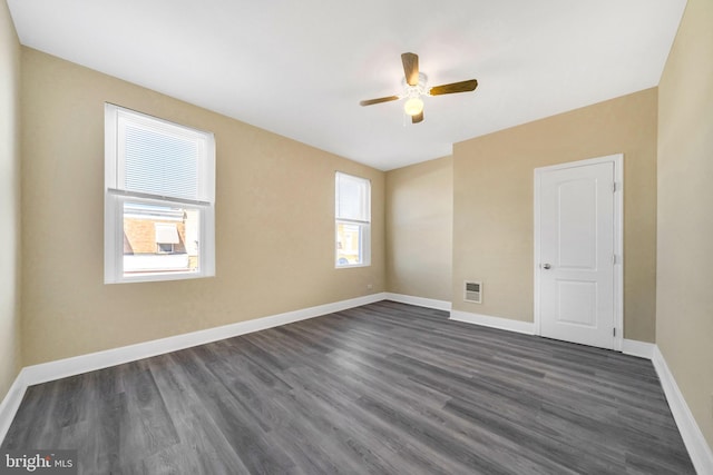 spare room with dark hardwood / wood-style floors and ceiling fan