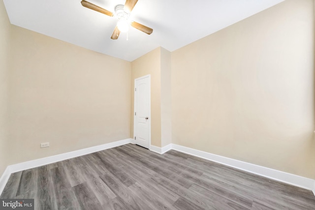 spare room with ceiling fan and dark wood-type flooring