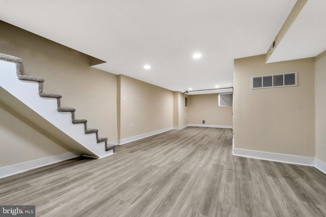 basement with light hardwood / wood-style flooring