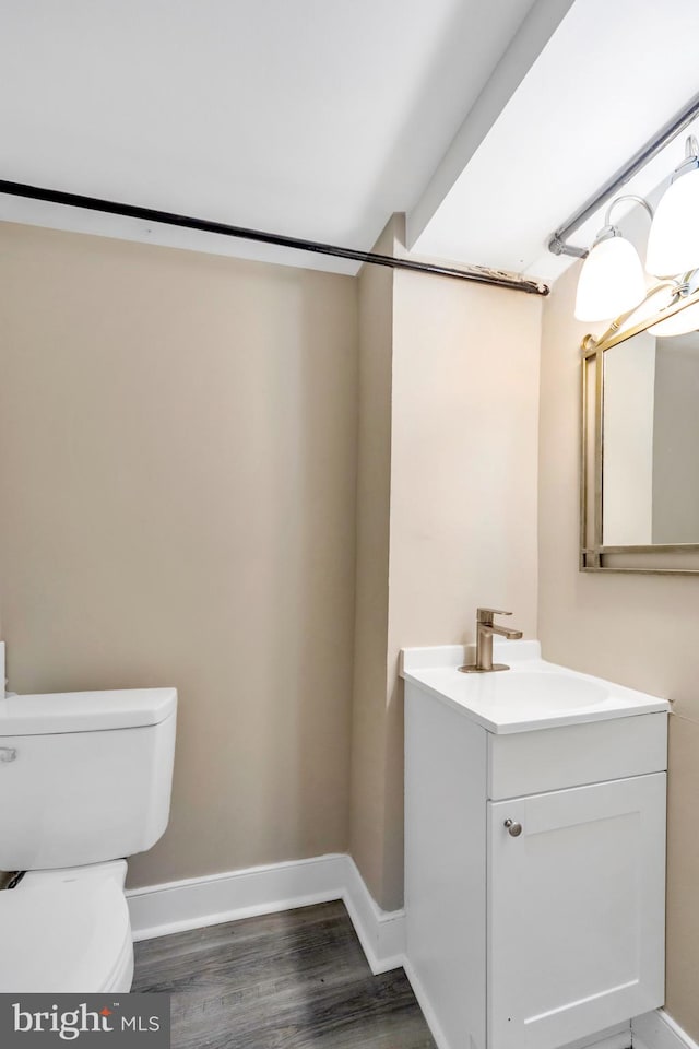 bathroom with hardwood / wood-style floors, vanity, and toilet