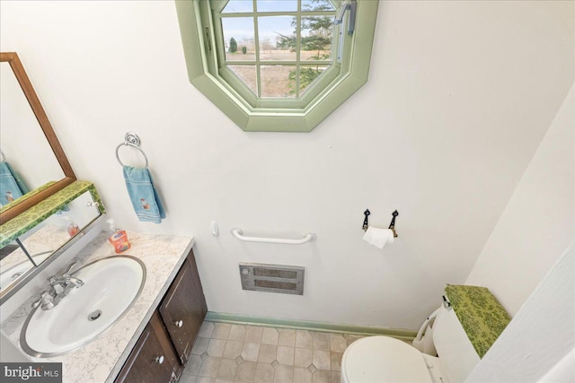 bathroom featuring vanity, toilet, and heating unit