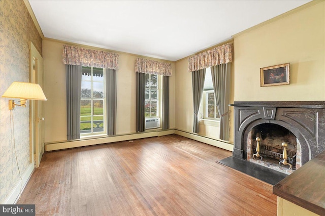 unfurnished living room with a baseboard heating unit, hardwood / wood-style flooring, and crown molding