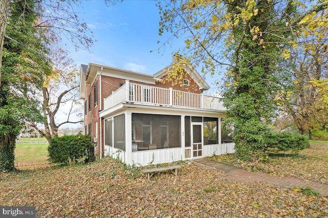 rear view of house with a balcony and a sunroom