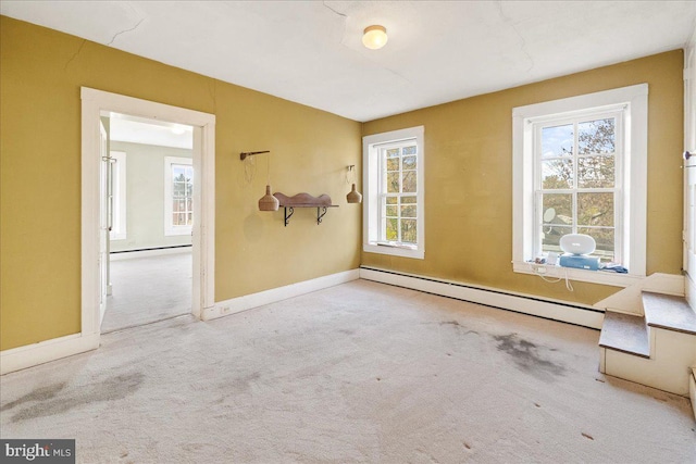 carpeted spare room featuring a baseboard heating unit