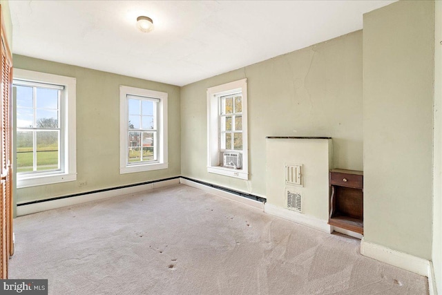 unfurnished room featuring plenty of natural light, light colored carpet, and a baseboard radiator