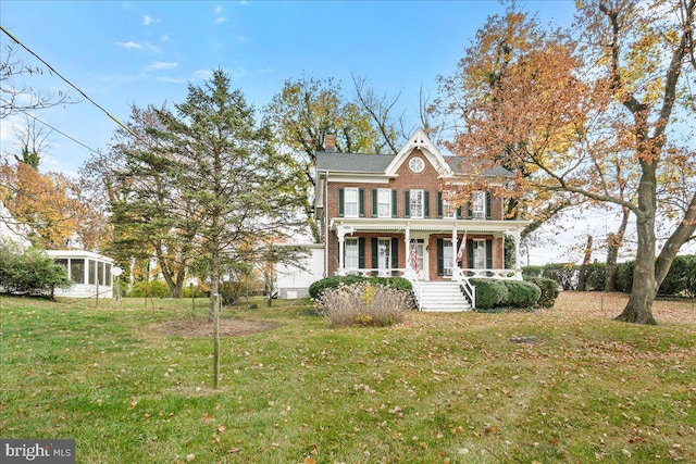 view of front of house with covered porch and a front yard