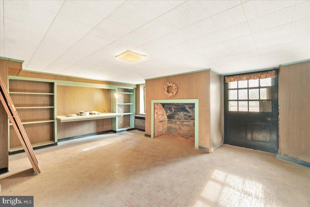 unfurnished living room featuring wood walls