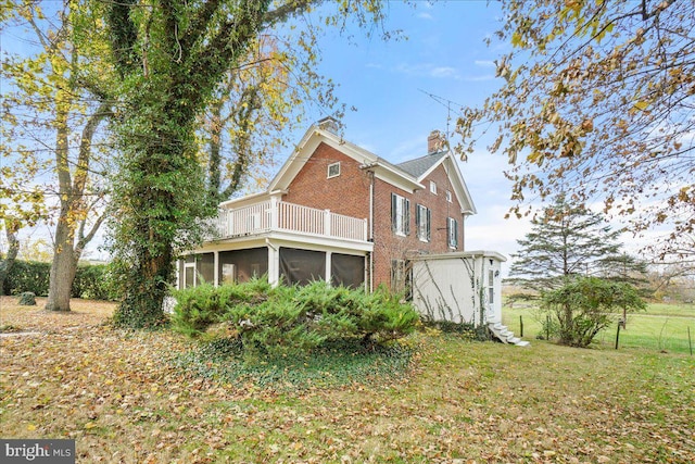 back of house featuring a sunroom and a balcony