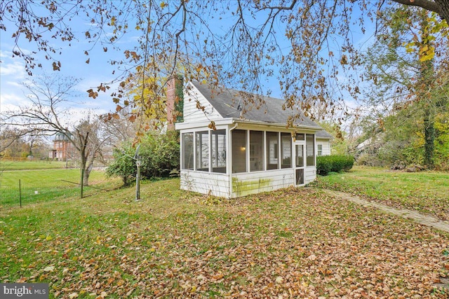 back of house with a sunroom and a yard