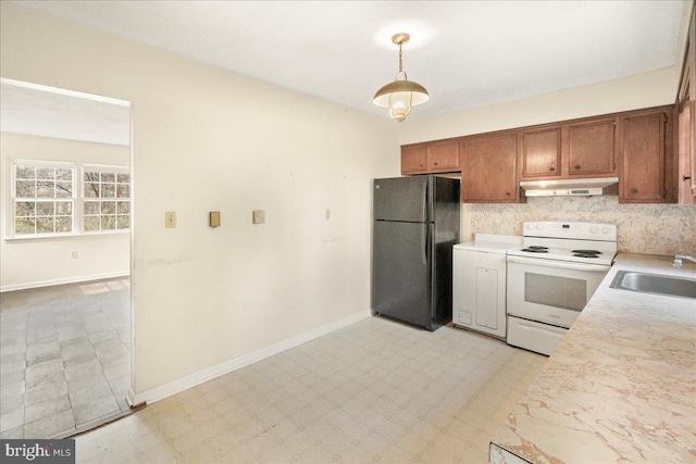 kitchen with sink, hanging light fixtures, tasteful backsplash, black fridge, and white range with electric cooktop