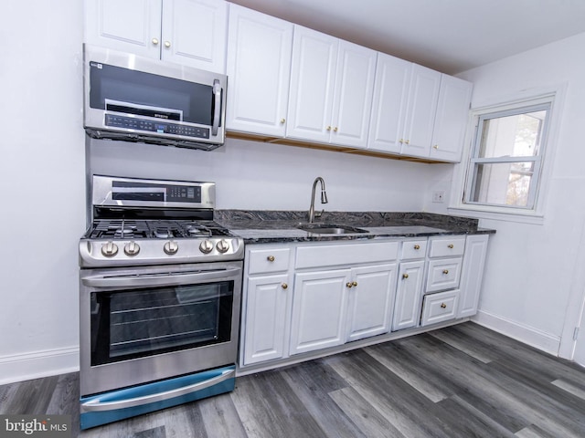 kitchen featuring white cabinets, appliances with stainless steel finishes, dark hardwood / wood-style floors, and sink