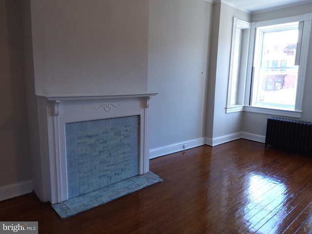 unfurnished living room featuring dark hardwood / wood-style flooring, plenty of natural light, and radiator