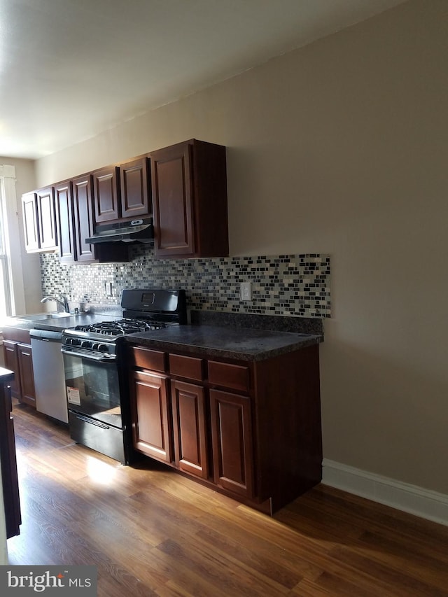 kitchen featuring dark wood-type flooring, stainless steel dishwasher, tasteful backsplash, gas stove, and dark brown cabinetry