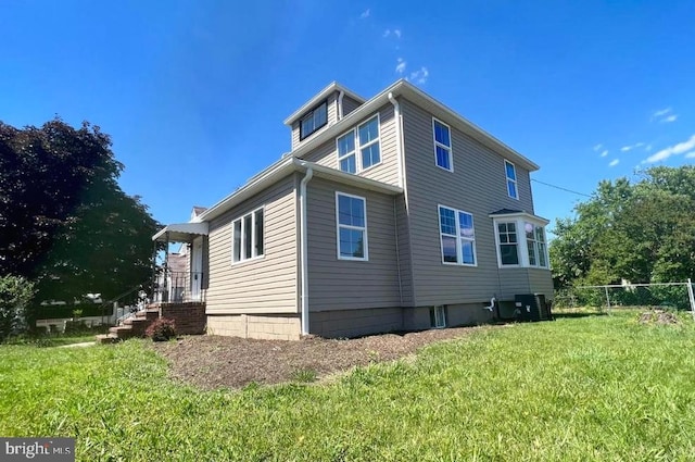 view of side of home featuring a yard and cooling unit