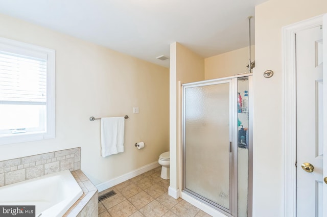 bathroom featuring tile patterned flooring, toilet, and shower with separate bathtub