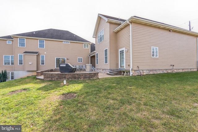 back of house featuring a patio area and a lawn