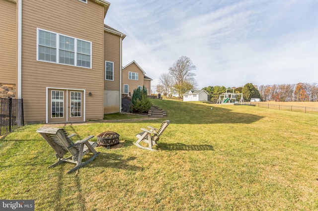 view of yard with a playground and an outdoor fire pit