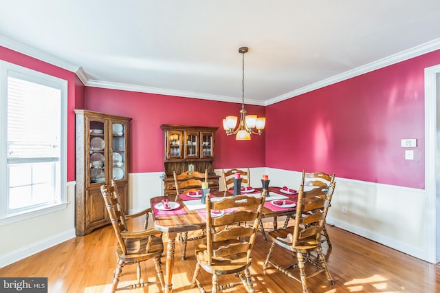 dining area featuring a notable chandelier, light hardwood / wood-style floors, and ornamental molding