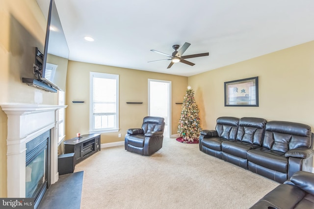 carpeted living room with ceiling fan