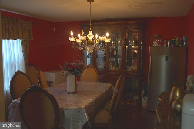 dining area with hardwood / wood-style floors and a notable chandelier