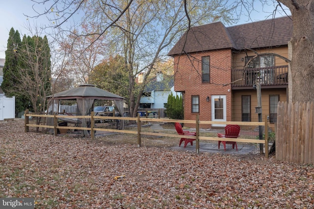 view of yard with a gazebo and a balcony