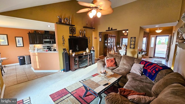 living room featuring ceiling fan, light tile patterned flooring, and high vaulted ceiling