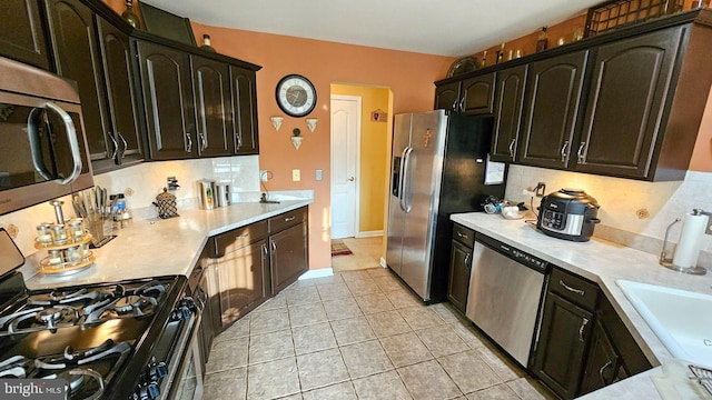 kitchen featuring decorative backsplash, light tile patterned floors, and stainless steel appliances