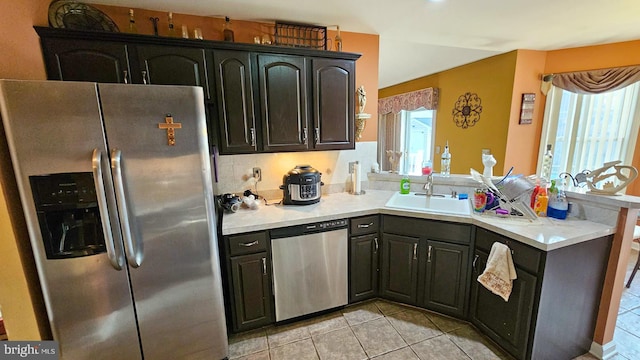 kitchen featuring light tile patterned flooring, stainless steel appliances, and sink