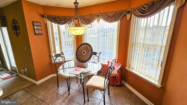 tiled dining room featuring plenty of natural light