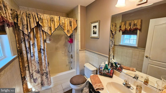 full bathroom with tile patterned floors, tile walls, toilet, vanity, and shower / tub combo