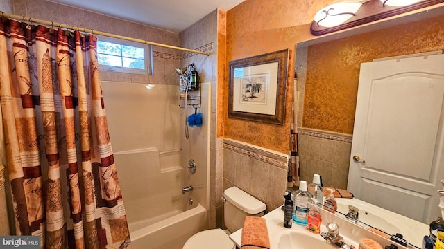 full bathroom with vanity, toilet, shower / bath combo with shower curtain, and tile walls