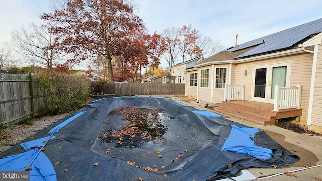 view of pool with french doors and a wooden deck