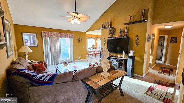 living room with ceiling fan, high vaulted ceiling, and light colored carpet