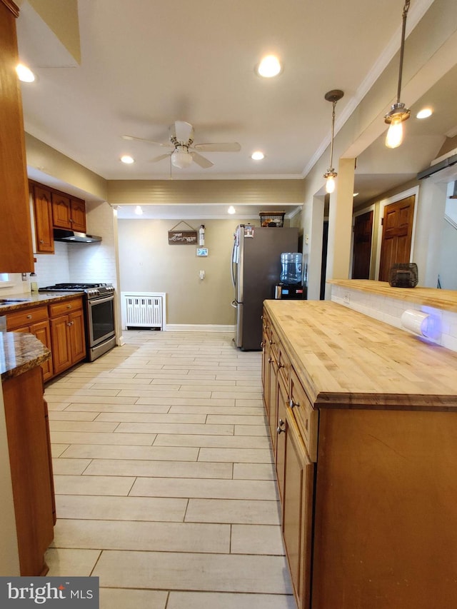 kitchen featuring ornamental molding, gas stove, ceiling fan, hanging light fixtures, and butcher block counters