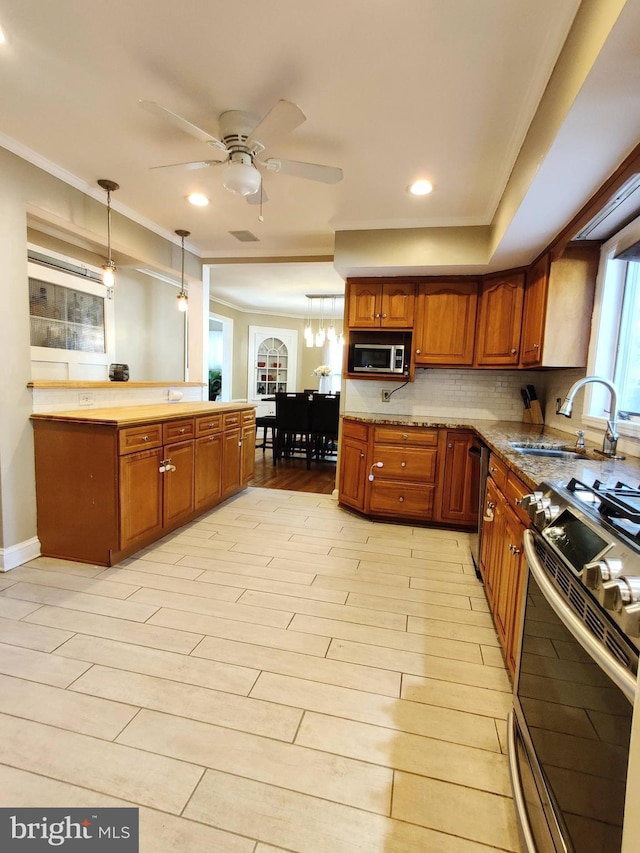 kitchen with ceiling fan, sink, hanging light fixtures, stainless steel appliances, and light wood-type flooring