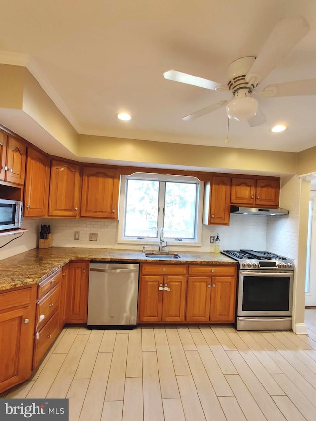 kitchen featuring ceiling fan, sink, stainless steel appliances, tasteful backsplash, and light hardwood / wood-style floors