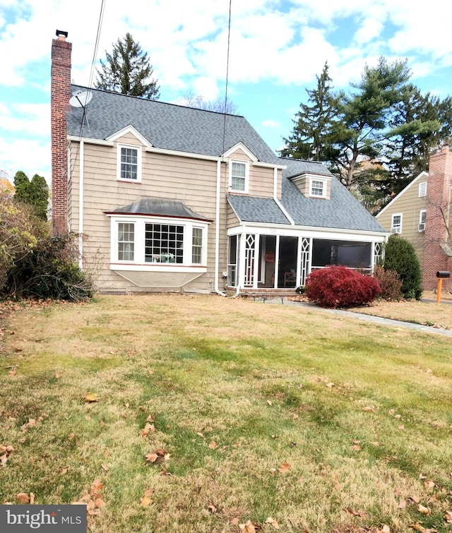 rear view of property with a lawn