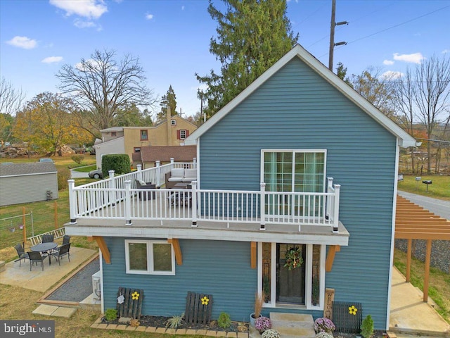 back of property featuring a patio and a wooden deck