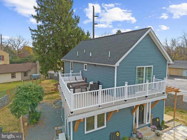 back of house featuring a balcony and an outdoor hangout area