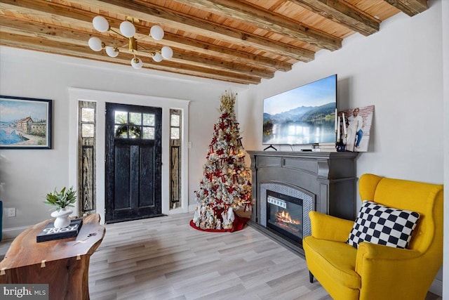 sitting room with beam ceiling, wooden ceiling, and light hardwood / wood-style flooring