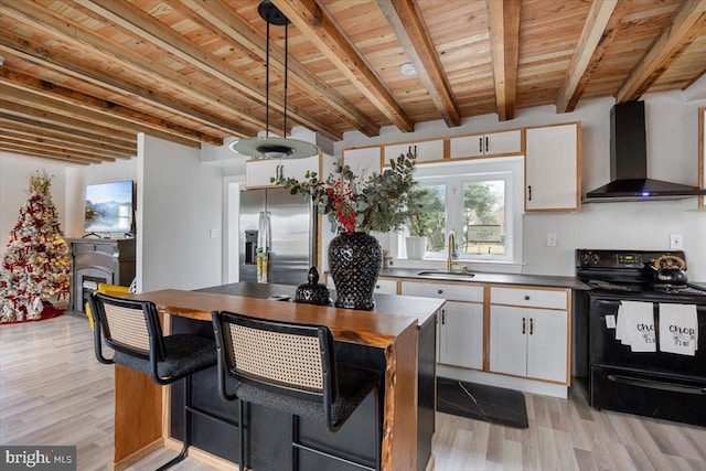 kitchen featuring wall chimney range hood, light wood-type flooring, black range with electric cooktop, white cabinetry, and stainless steel fridge with ice dispenser