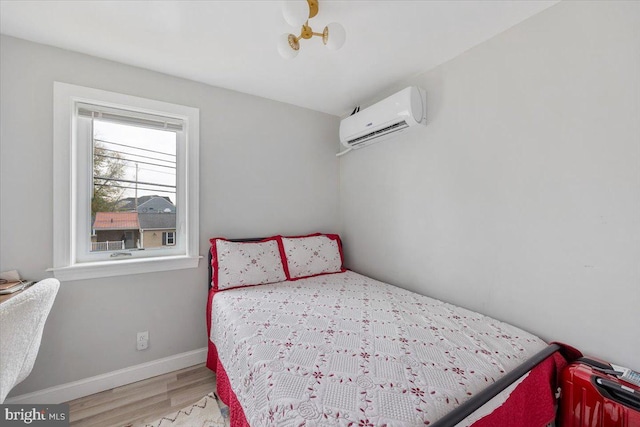 bedroom featuring wood-type flooring and a wall mounted AC