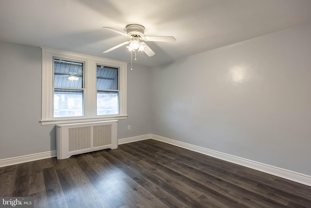 spare room with ceiling fan, dark wood-type flooring, and radiator