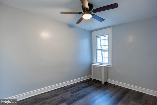 spare room with radiator, dark hardwood / wood-style flooring, and ceiling fan