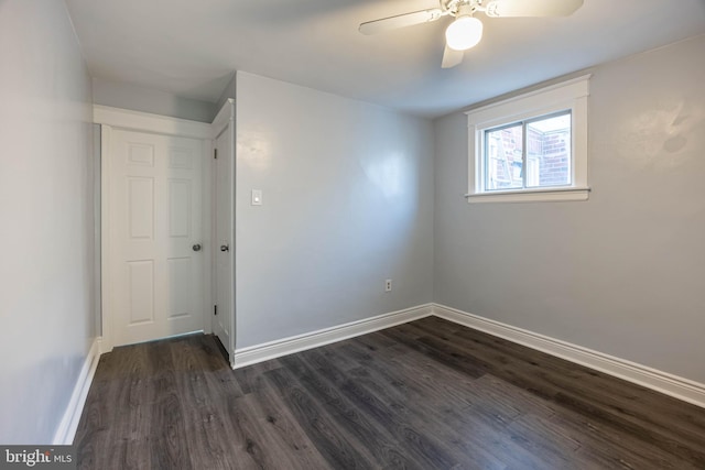 empty room with dark hardwood / wood-style floors and ceiling fan