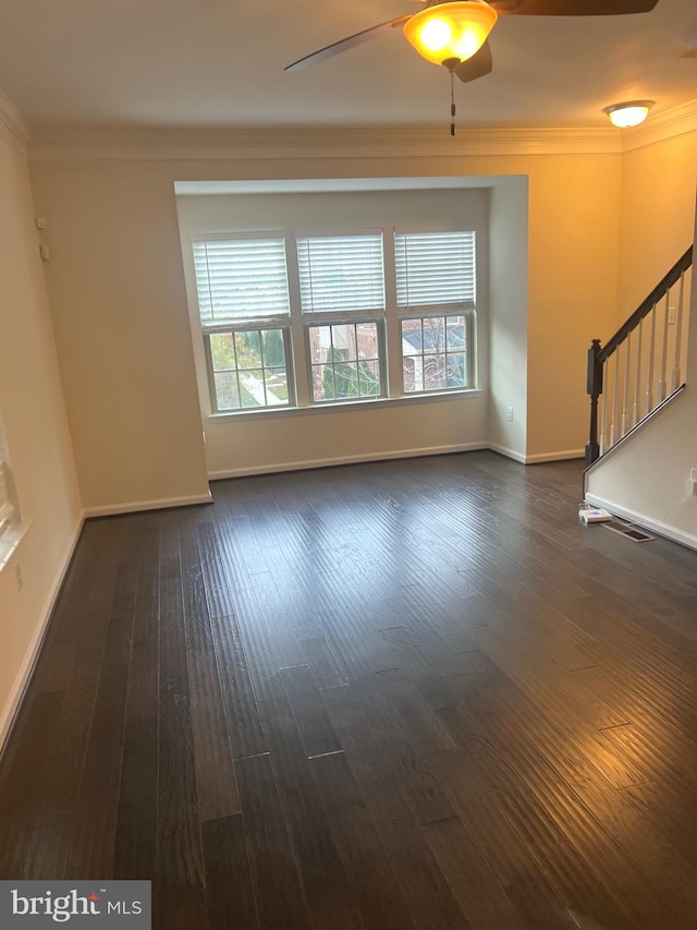 interior space featuring ceiling fan, ornamental molding, and dark wood-type flooring