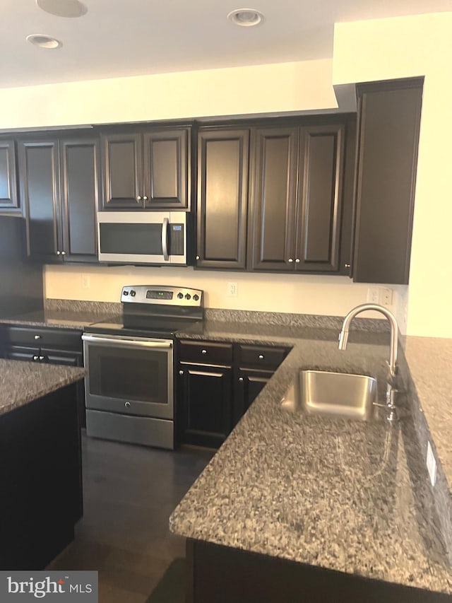 kitchen featuring stone countertops, sink, and stainless steel appliances