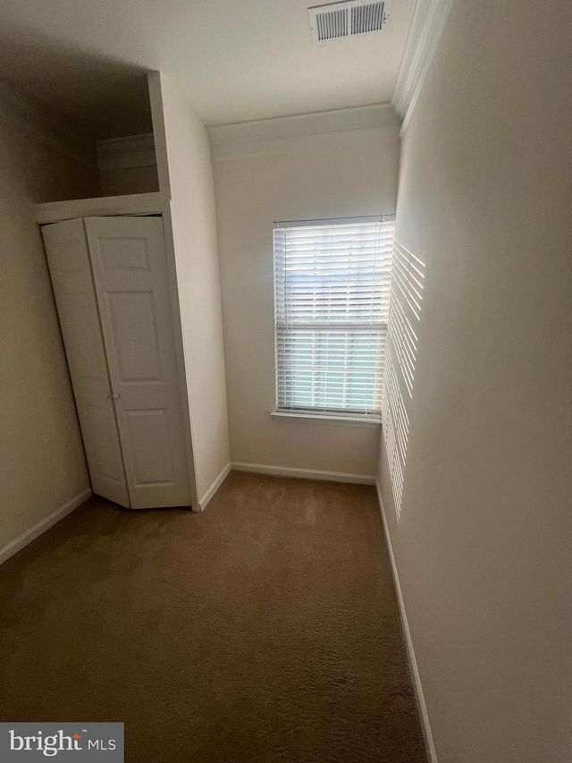 unfurnished bedroom featuring carpet floors, a closet, and crown molding